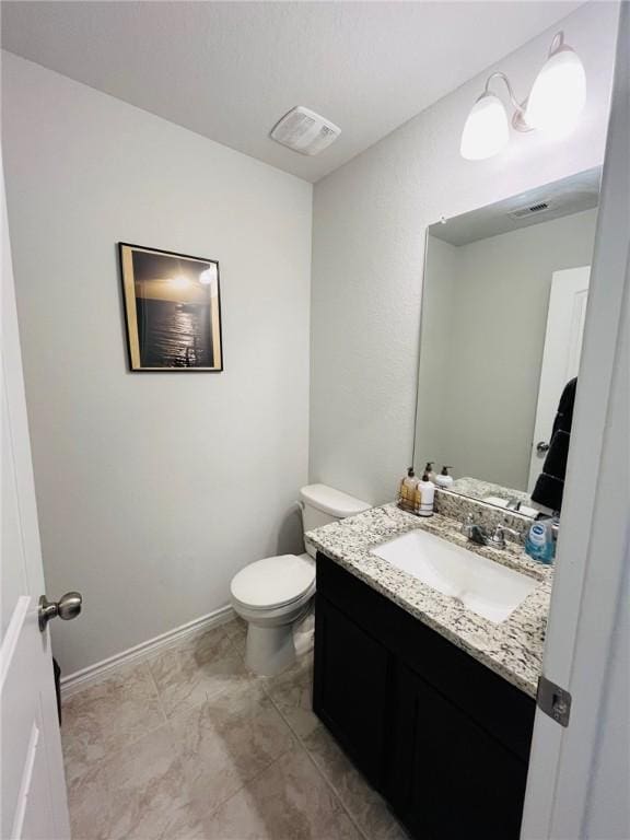 bathroom with tile patterned flooring, vanity, and toilet