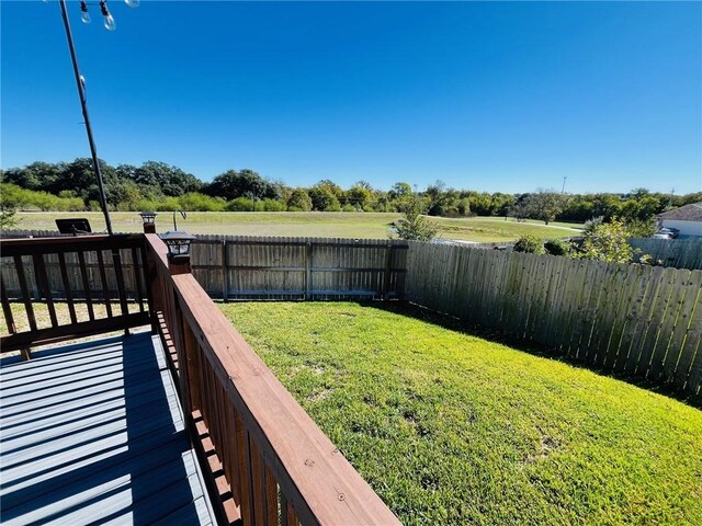 view of yard featuring a rural view and a wooden deck