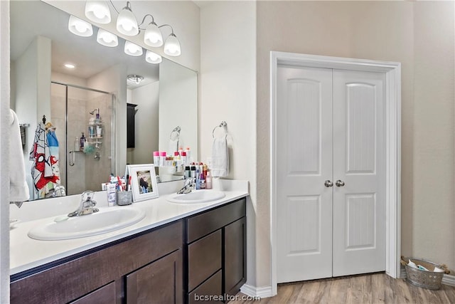 bathroom featuring vanity, wood-type flooring, and a shower with door