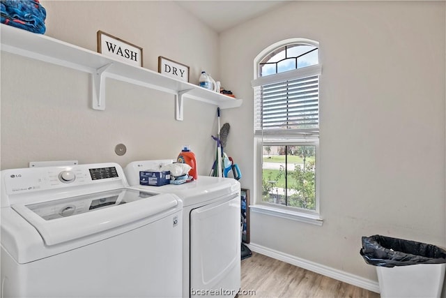 clothes washing area with a healthy amount of sunlight, light wood-type flooring, and independent washer and dryer