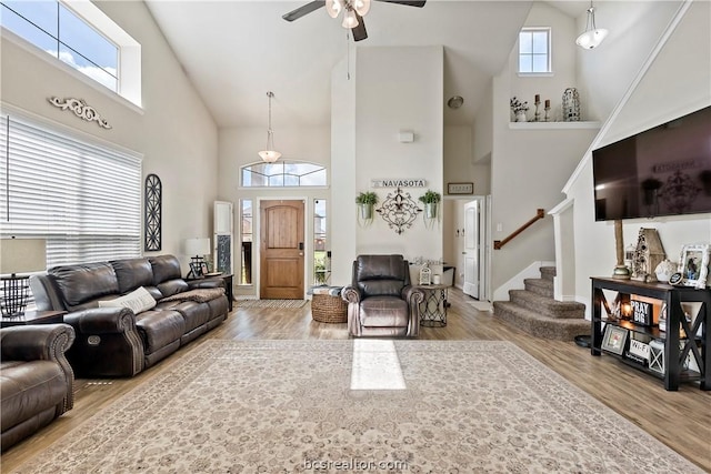 living room with wood-type flooring, high vaulted ceiling, a wealth of natural light, and ceiling fan