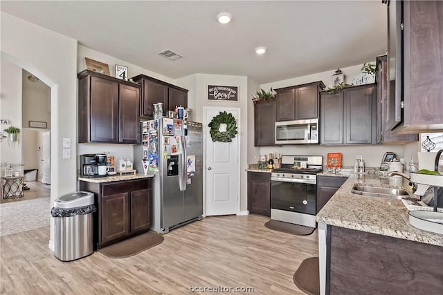 kitchen featuring dark brown cabinets, stainless steel appliances, light hardwood / wood-style floors, and sink