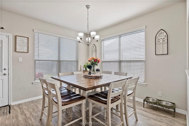 dining space with a chandelier and light wood-type flooring