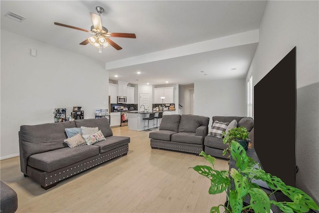 living room featuring ceiling fan and light wood-type flooring