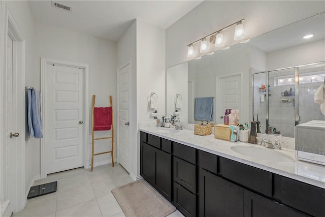 bathroom featuring a shower with door, tile patterned floors, and vanity