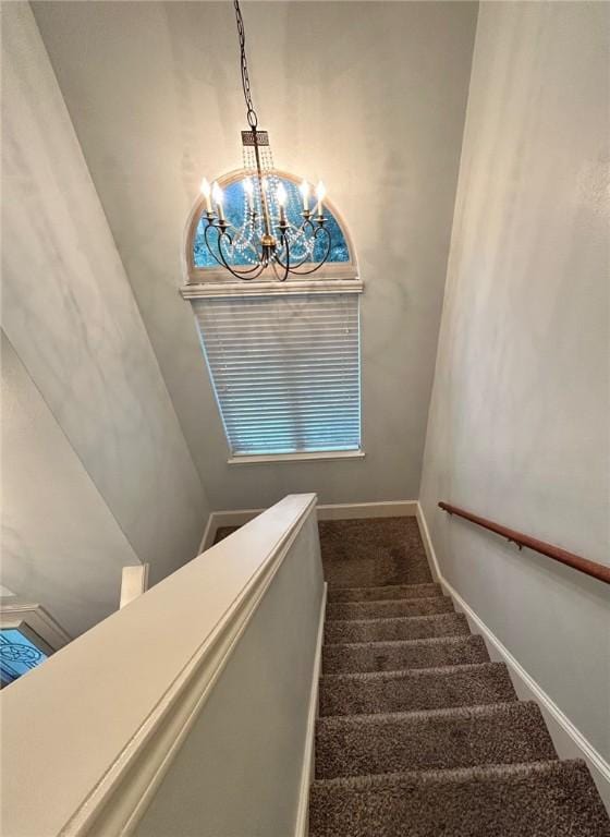 staircase featuring carpet and a notable chandelier