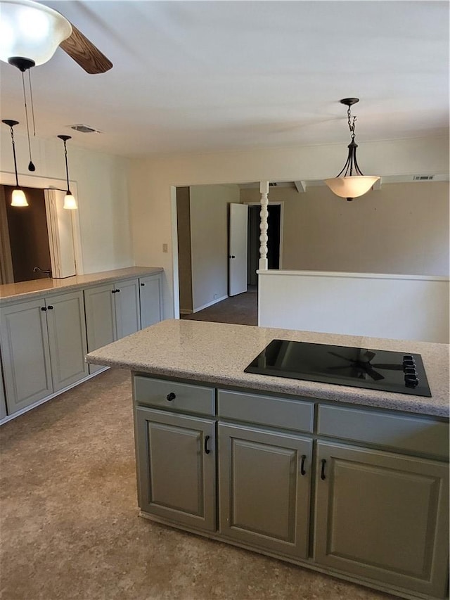 kitchen featuring black electric stovetop, gray cabinets, ceiling fan, and pendant lighting