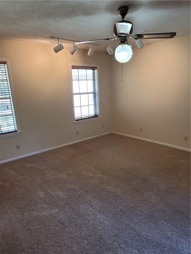 carpeted spare room featuring ceiling fan, track lighting, and a textured ceiling