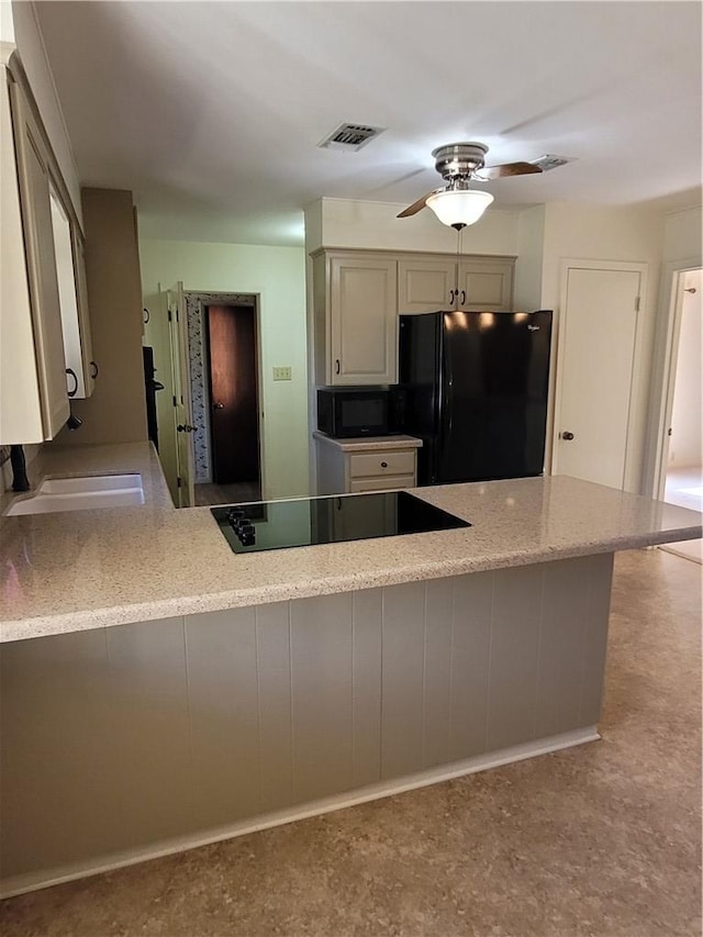 kitchen with kitchen peninsula, sink, ceiling fan, and black appliances