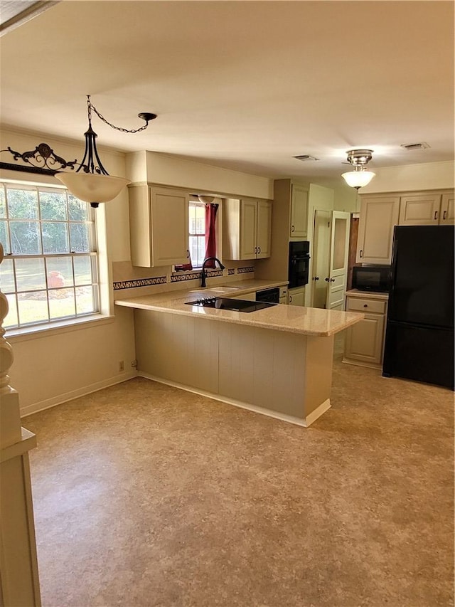 kitchen featuring kitchen peninsula, pendant lighting, a wealth of natural light, and black appliances