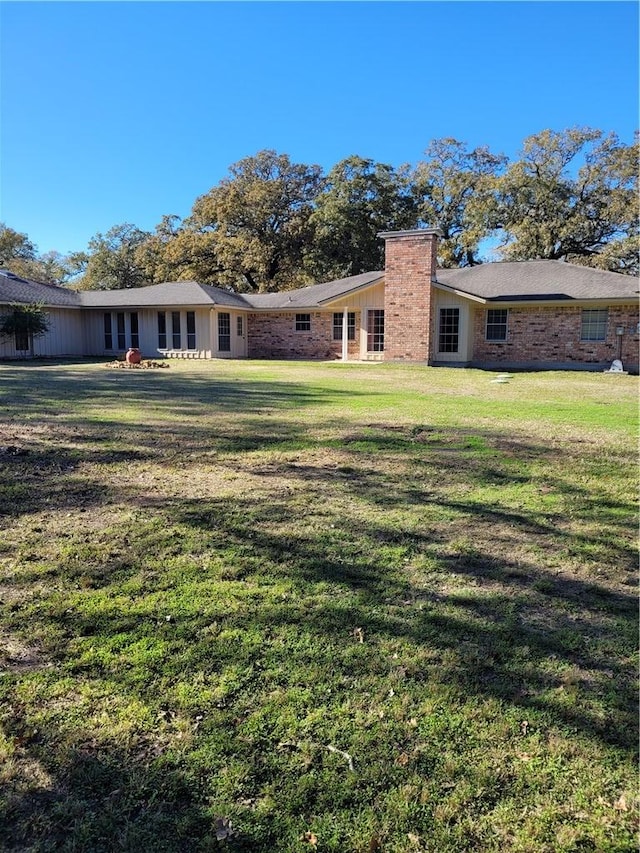 rear view of property featuring a lawn