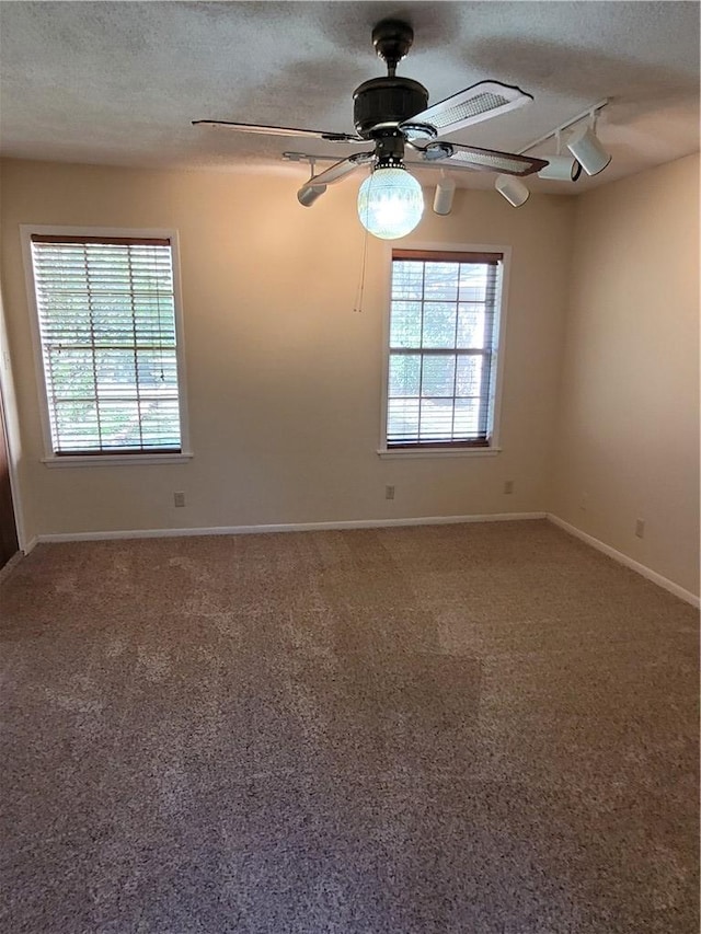 unfurnished room featuring ceiling fan, carpet, a textured ceiling, and rail lighting