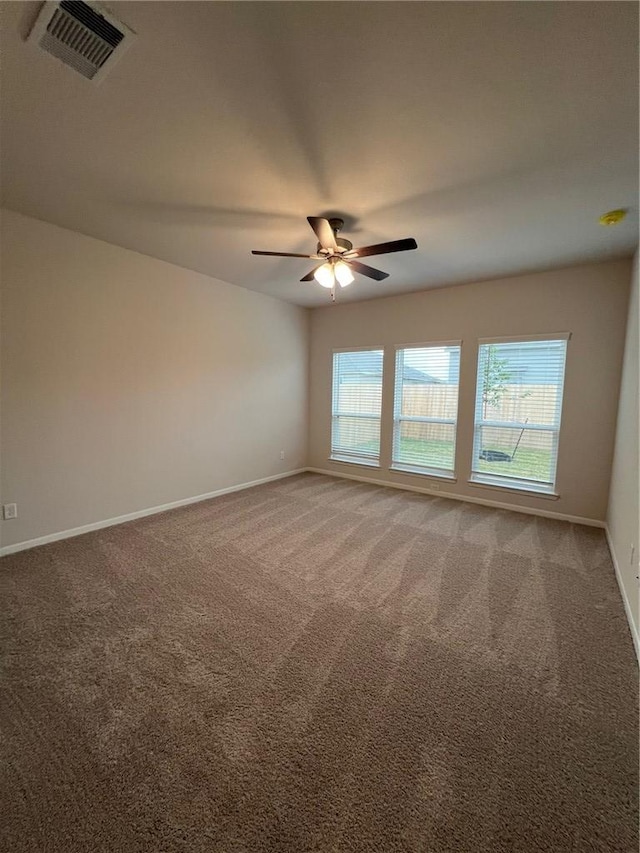 carpeted spare room with ceiling fan and a wealth of natural light