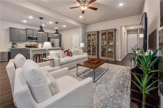 living room featuring ceiling fan and dark wood-type flooring