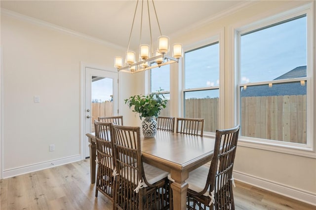 dining room featuring light hardwood / wood-style floors, a notable chandelier, and ornamental molding