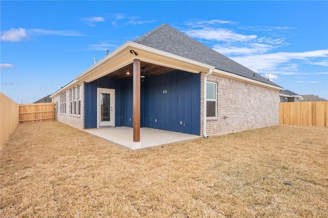 rear view of house featuring a patio area and a lawn