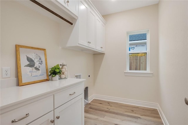 washroom featuring hookup for a washing machine, cabinets, hookup for an electric dryer, and light wood-type flooring