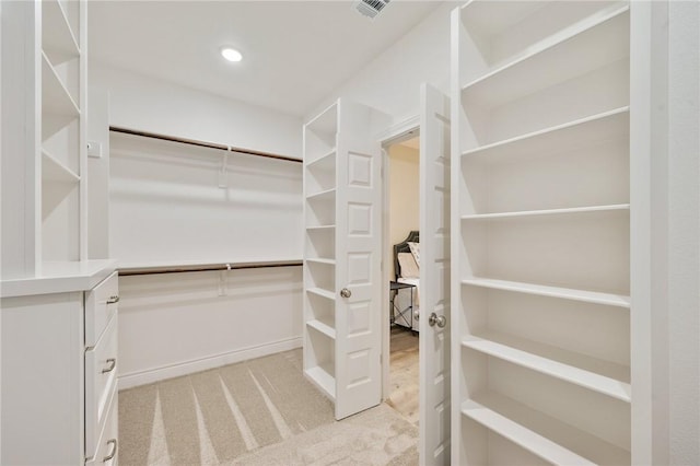 walk in closet featuring light carpet