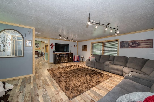 living room featuring hardwood / wood-style flooring, crown molding, track lighting, and a textured ceiling