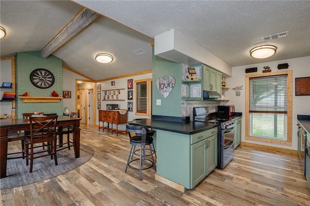 kitchen featuring vaulted ceiling with beams, a kitchen bar, range with two ovens, green cabinets, and light hardwood / wood-style flooring