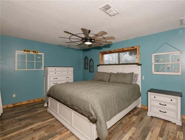 bedroom featuring dark wood-type flooring, ceiling fan, and a textured ceiling