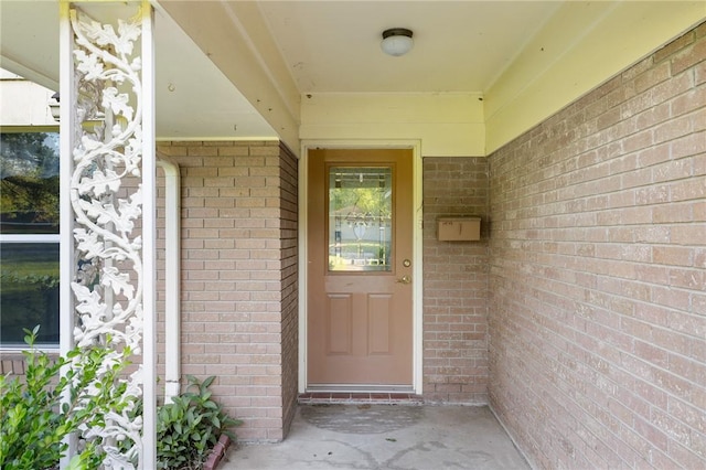 view of exterior entry featuring brick siding