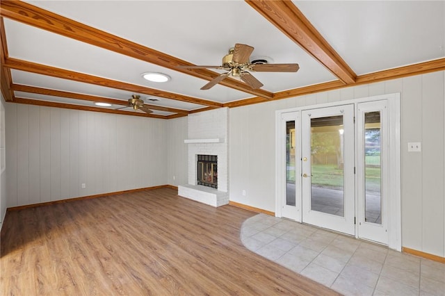 unfurnished living room with light wood-style flooring, french doors, ceiling fan, and beam ceiling