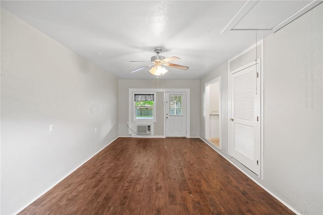 interior space with ceiling fan, wood finished floors, and a wall mounted air conditioner