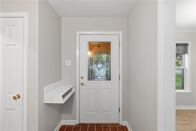 doorway to outside featuring baseboards, plenty of natural light, and wood finished floors