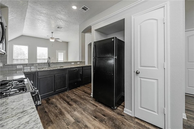 kitchen with visible vents, dark wood-style flooring, black appliances, and a sink