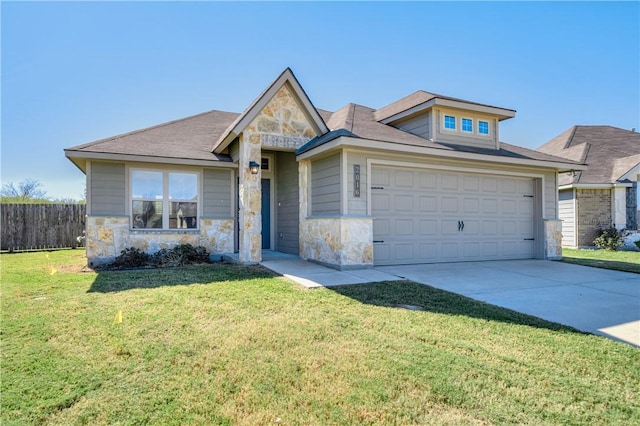 view of front of house featuring driveway, stone siding, fence, a front yard, and an attached garage