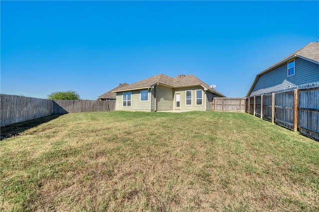 back of property with a yard and a fenced backyard