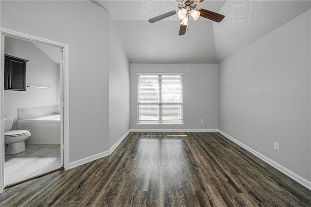 interior space featuring baseboards, lofted ceiling, and dark wood-style floors