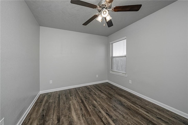 spare room with a ceiling fan, dark wood-style floors, baseboards, and a textured ceiling