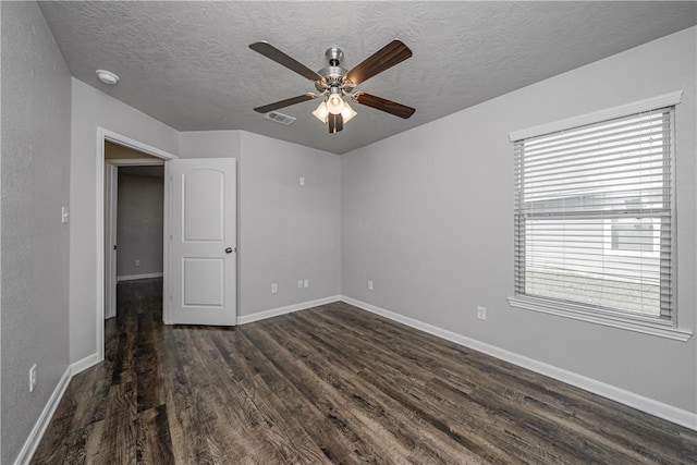 unfurnished room with visible vents, baseboards, dark wood finished floors, a textured ceiling, and a ceiling fan