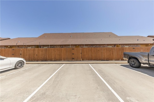 uncovered parking lot featuring fence