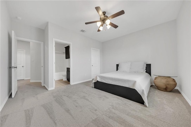 bedroom with baseboards, visible vents, ceiling fan, light carpet, and connected bathroom