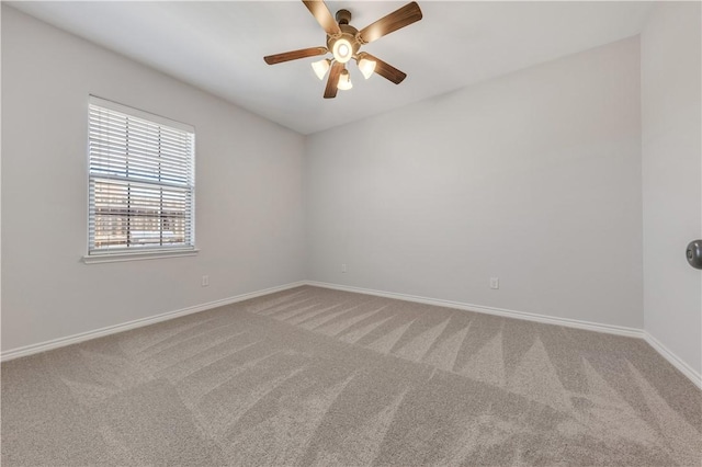 carpeted empty room featuring baseboards and a ceiling fan