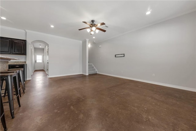 unfurnished living room featuring finished concrete flooring, baseboards, recessed lighting, arched walkways, and ceiling fan