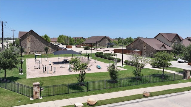 view of property's community featuring a lawn and fence
