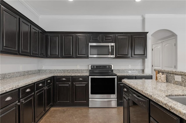 kitchen with dark cabinets, appliances with stainless steel finishes, and ornamental molding