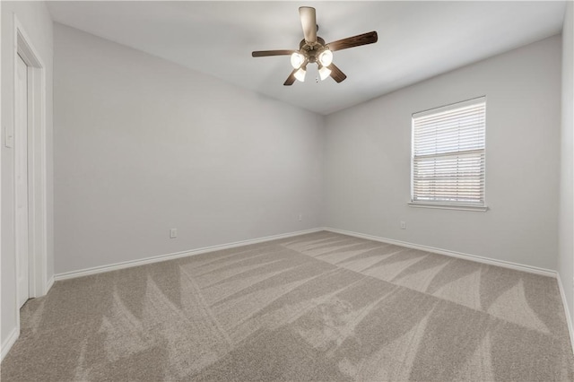 carpeted spare room with baseboards and a ceiling fan
