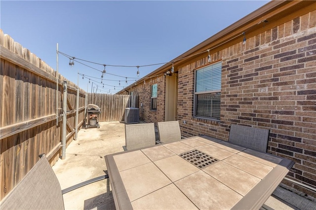 view of patio / terrace featuring outdoor dining space, central air condition unit, and a fenced backyard