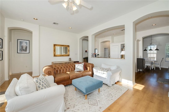 living room with light hardwood / wood-style flooring and ceiling fan