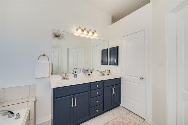 bathroom with a tub to relax in, vanity, and tile patterned flooring