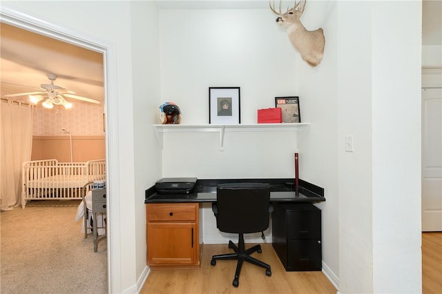 home office with light hardwood / wood-style flooring and ceiling fan