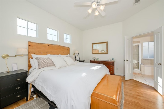 bedroom featuring light wood-type flooring, connected bathroom, and ceiling fan