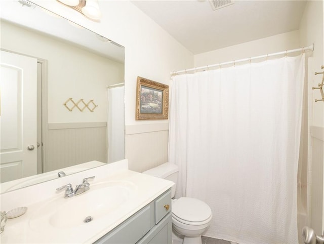 full bathroom featuring vanity, shower / bath combo, wooden walls, and toilet