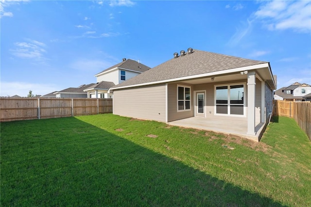 rear view of house featuring a yard and a patio