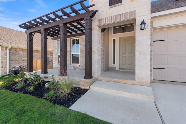 entrance to property with a garage and a pergola